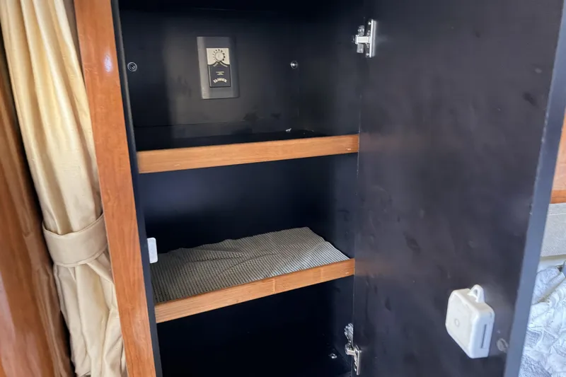  Yacht Photos Pics Open cabinet with shelves inside a 2006 Sea Ray 340 Sundancer boat interior.