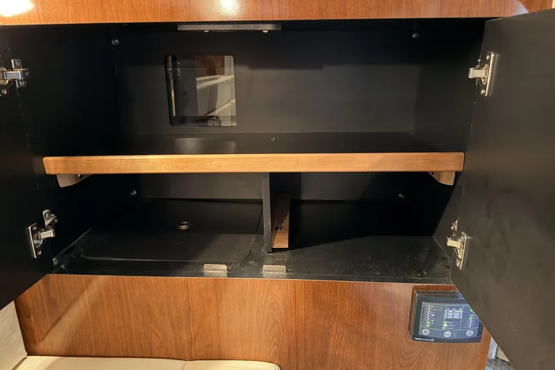  Yacht Photos Pics Open cabinet in 2006 Sea Ray 340 Sundancer boat interior, featuring wooden shelves.