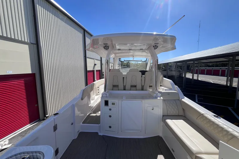  Yacht Photos Pics 2019 Regal 33 SAV boat interior with seating and storage, docked under clear sky.