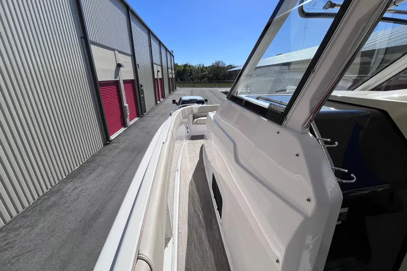  Yacht Photos Pics 2019 Regal 33 SAV boat docked beside storage units under clear blue sky.