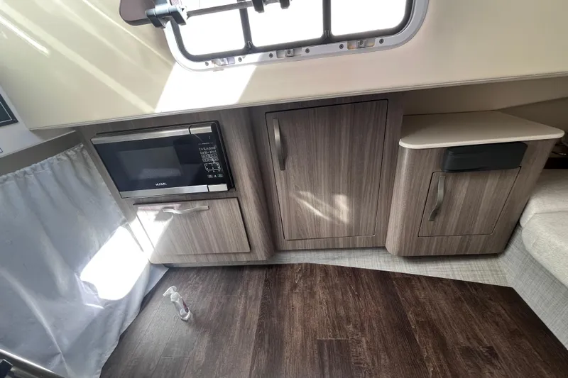  Yacht Photos Pics 2019 Regal 33 SAV interior with microwave, cabinets, and wood flooring.