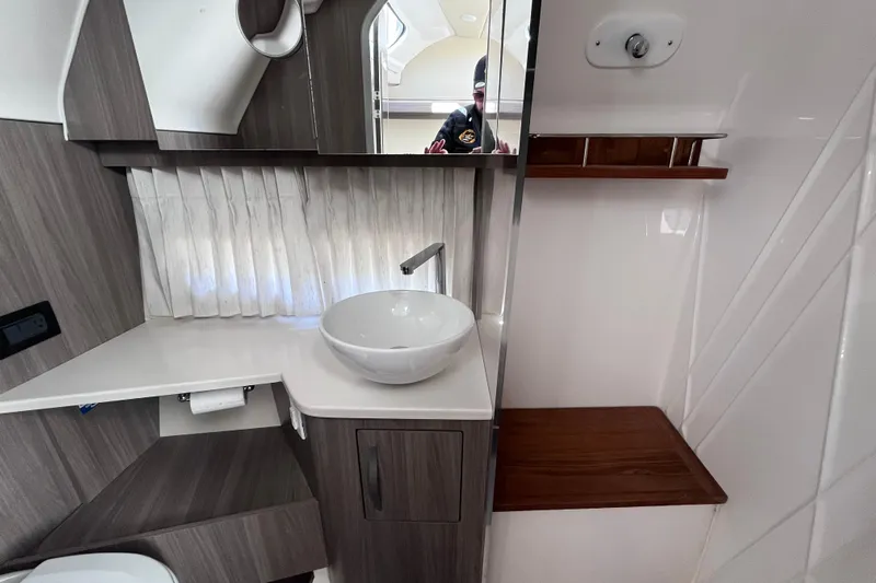  Yacht Photos Pics Modern bathroom interior of 2019 Regal 33 SAV boat with sleek sink and wood accents.