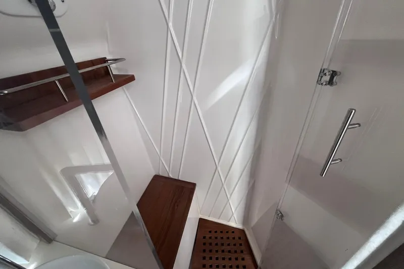  Yacht Photos Pics Shower area in 2019 Regal 33 SAV boat with wooden accents and glass door.