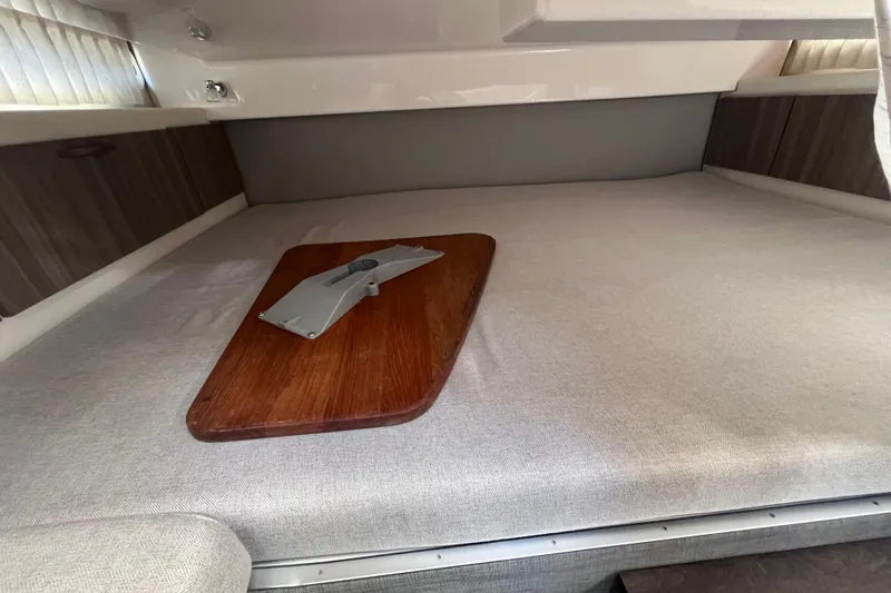  Yacht Photos Pics Interior cabin of 2019 Regal 33 SAV boat with wooden table and cushioned seating.