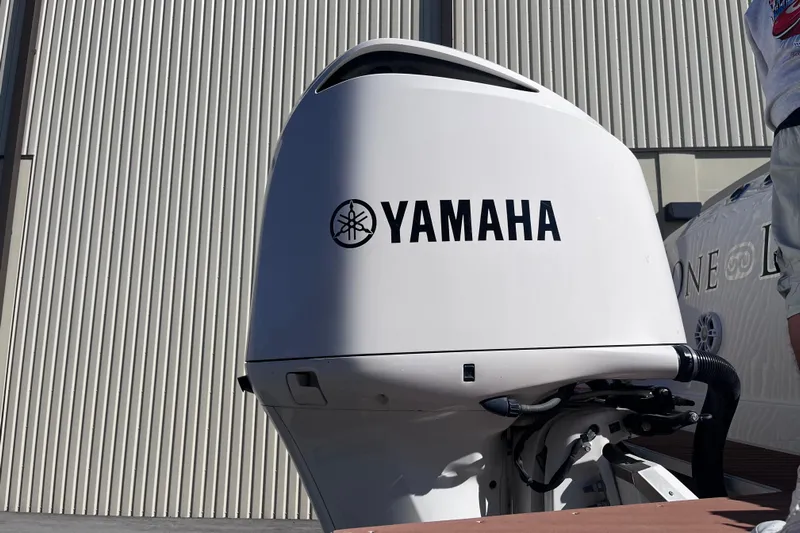  Yacht Photos Pics Yamaha outboard motor on 2019 Regal 33 SAV boat, docked near a corrugated building.