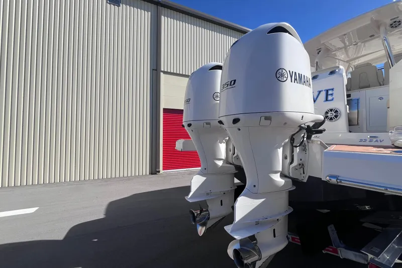  Yacht Photos Pics 2019 Regal 33 SAV boat with twin Yamaha 350 outboard engines, docked near a storage facility.