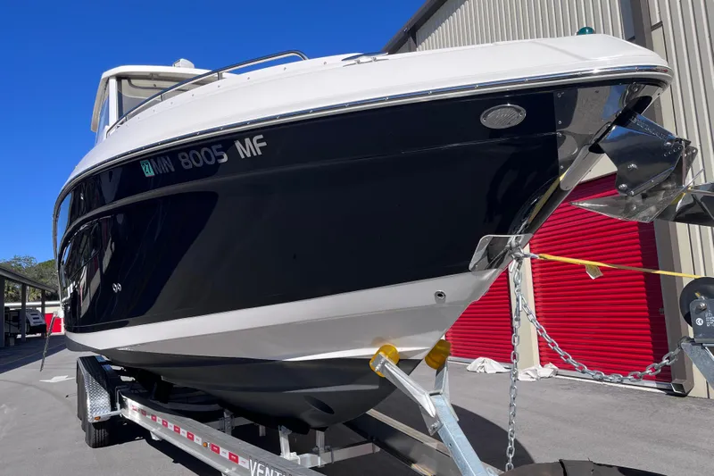  Yacht Photos Pics 2019 Regal 33 SAV boat on trailer, parked near red storage units.