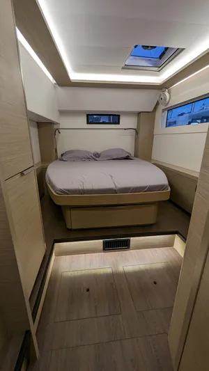 Boatylicious Yacht Photos Pics 2022 Lagoon 46 yacht cabin with modern design, featuring a cozy bed and ambient lighting.