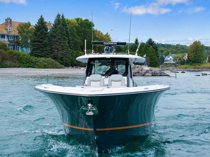  Yacht Photos Pics 2023 Scout 425 LXF boat cruising on a scenic lake with lush greenery.