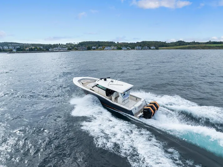  Yacht Photos Pics 2023 Scout 425 LXF boat cruising on open water, scenic coastal background.