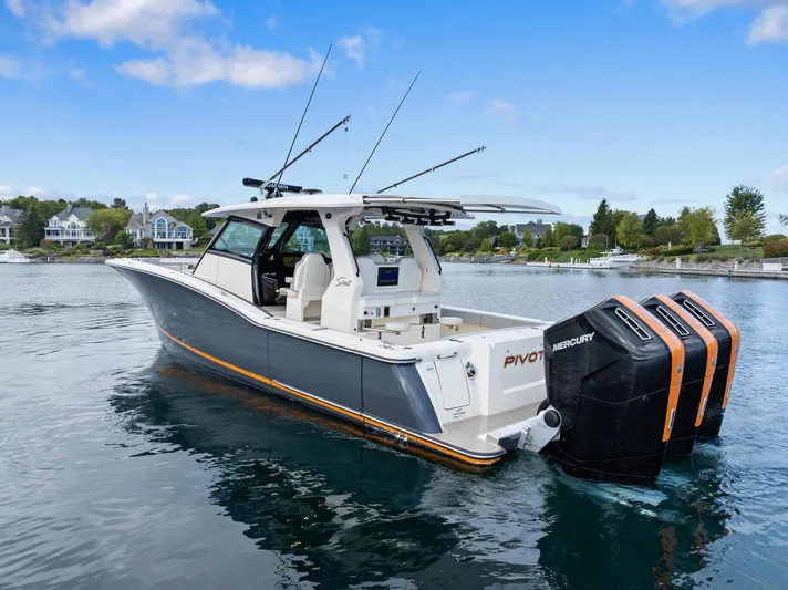  Yacht Photos Pics 2023 Scout 425 LXF boat with triple Mercury engines on a calm lake.