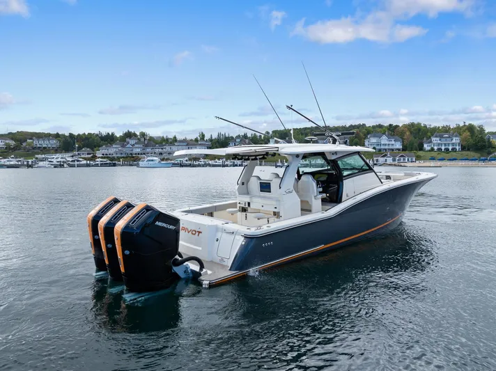  Yacht Photos Pics 2023 Scout 425 LXF boat with triple engines on a calm lake.