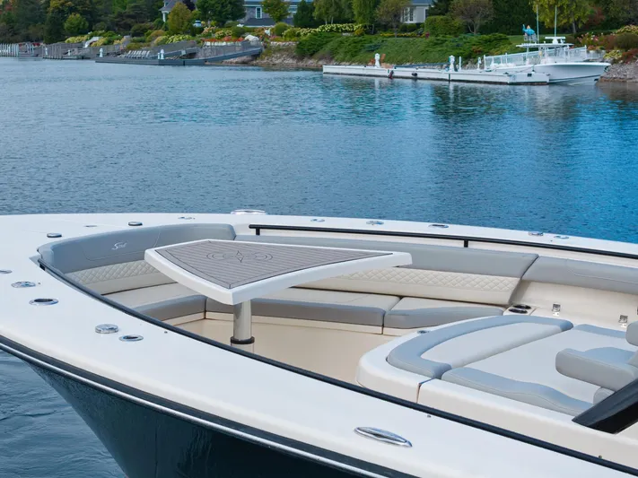  Yacht Photos Pics 2023 Scout 425 LXF luxury boat with elegant seating and table on calm water.