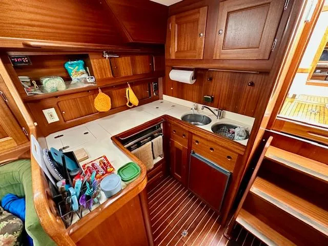  Yacht Photos Pics Compact wooden kitchen in 2002 Vilm 116 yacht with sink, stove, and storage.