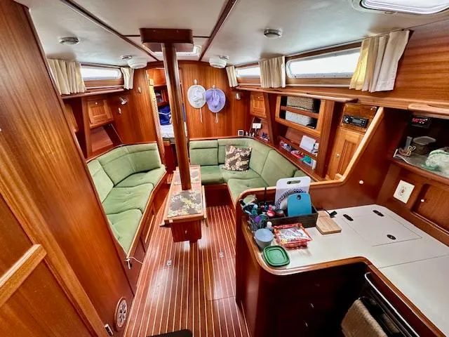  Yacht Photos Pics Cozy interior of 2002 Vilm 116 yacht with wooden finish and green seating.