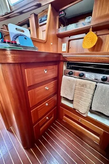  Yacht Photos Pics Wooden yacht kitchen interior with stove, drawers, and hanging towel. Vilm 116, 2002 model.