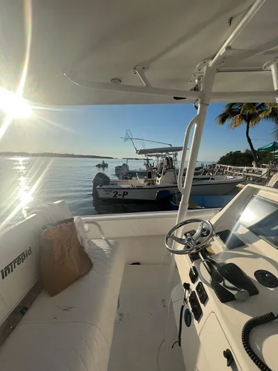 30 Intrepid Center Console Yacht Photos Pics 2004 Intrepid 300 Center Console boat docked at sunset, featuring steering controls and a serene waterfront view.