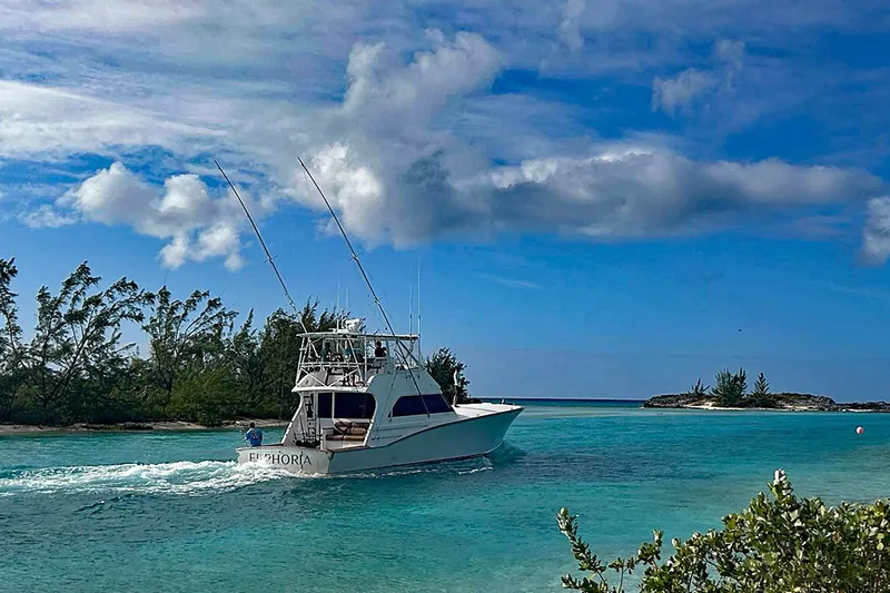 Euphoria Yacht Photos Pics Custom Carolina Precision Sportfish 2000 cruising in clear turquoise waters under a blue sky.
