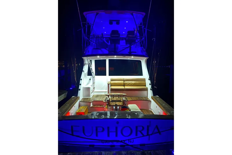 Euphoria Yacht Photos Pics 2000 Custom Carolina Precision Sportfish boat with blue lighting at night, named "Euphoria."
