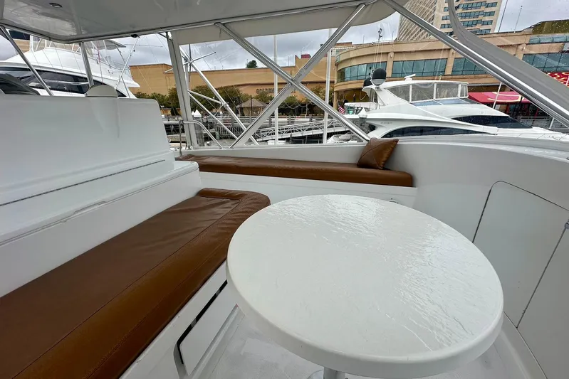 Euphoria Yacht Photos Pics Interior of 2000 Custom Carolina Precision Sportfish with white table and brown seating.