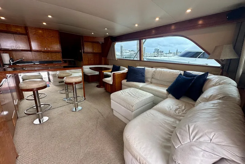 Euphoria Yacht Photos Pics Luxurious interior of 2000 Custom Carolina Precision Sportfish yacht with plush seating and bar stools.