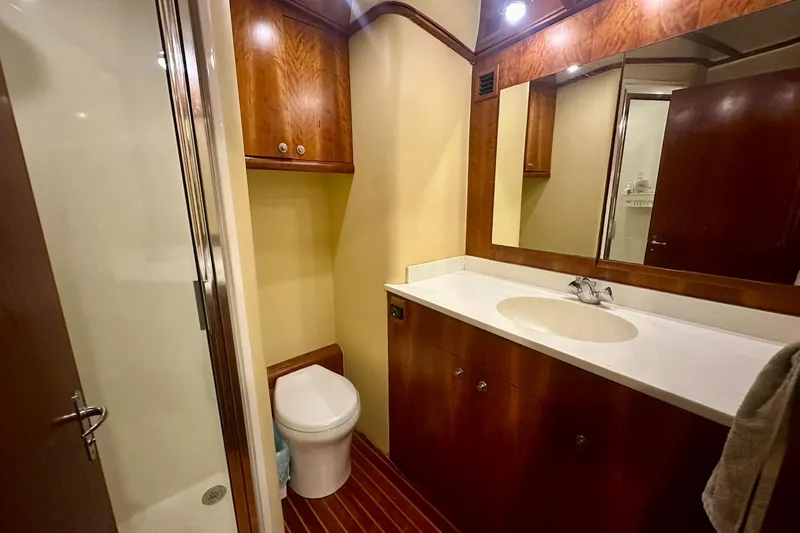 Euphoria Yacht Photos Pics Luxurious bathroom in 2000 Custom Carolina Precision Sportfish yacht, featuring wood cabinetry and modern fixtures.