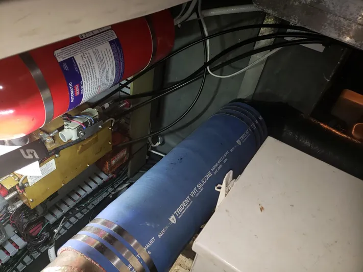 Escondite Yacht Photos Pics Engine compartment of a 2001 Sea Ray 410 Sundancer with fire extinguisher and blue hose visible.