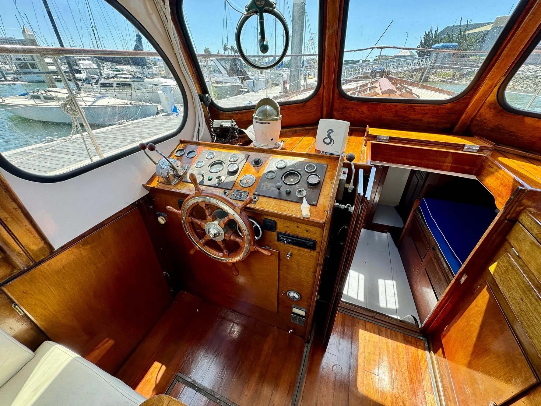 Vintage 1966 Rampart 48 boat interior with wooden helm and nautical instruments.