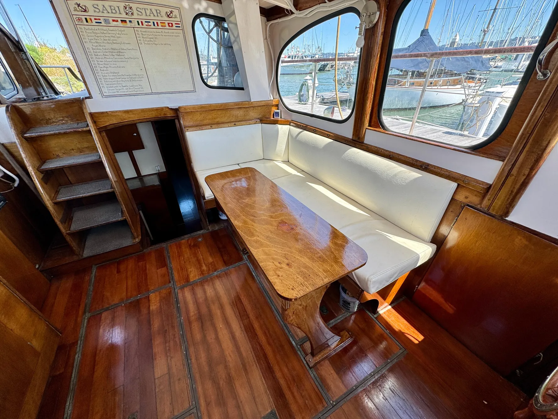 Interior of a 1966 Rampart 48 yacht with wooden flooring and seating area.