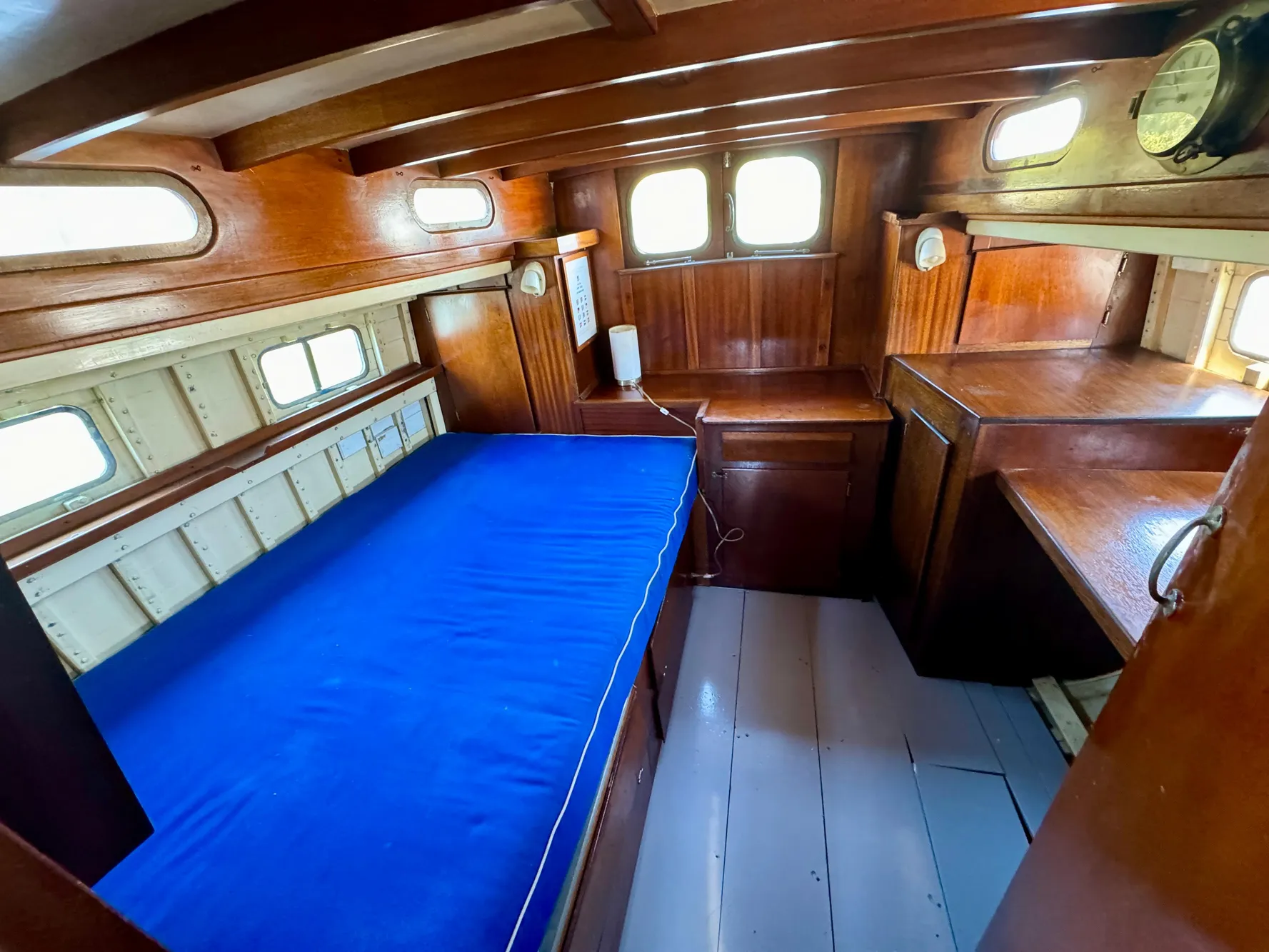 1966 Rampart 48 boat interior with wooden furnishings and blue bedding.