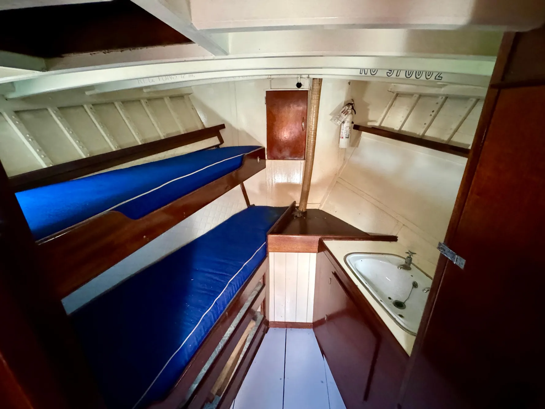 Interior of a 1966 Rampart 48 boat with bunk beds and a small sink.