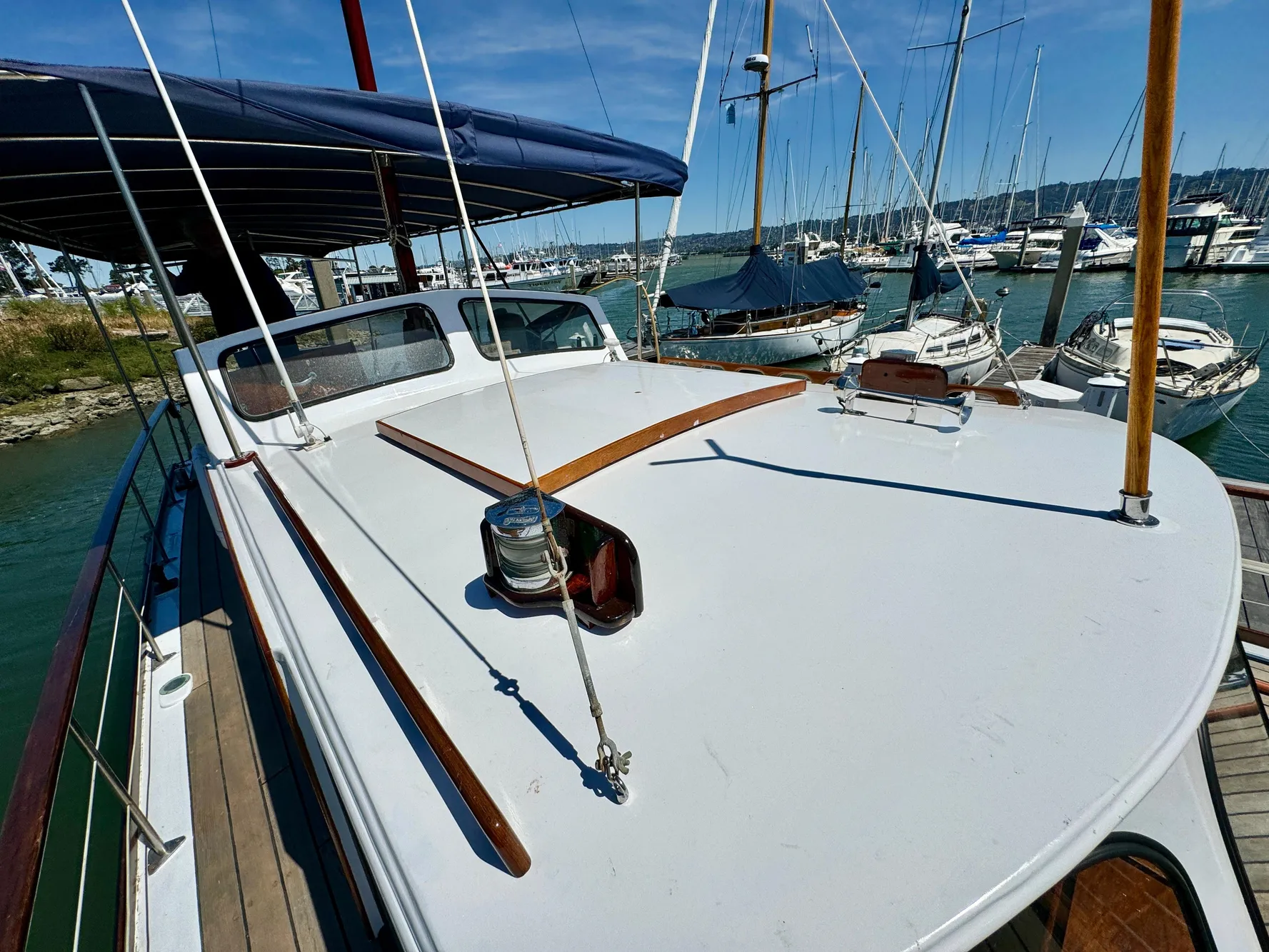 1966 Rampart 48 yacht deck with marina background, featuring classic wooden details.