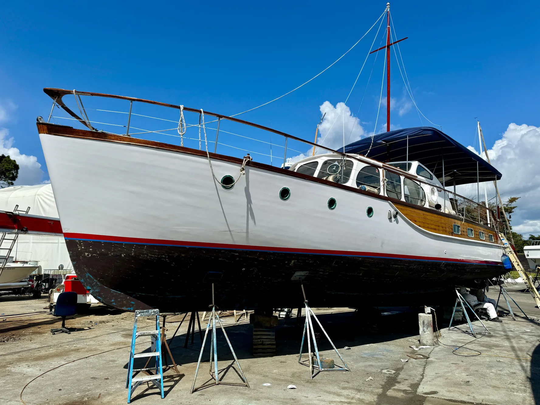 1966 Rampart 48 yacht on dry dock, showcasing classic design and elegant wooden details.