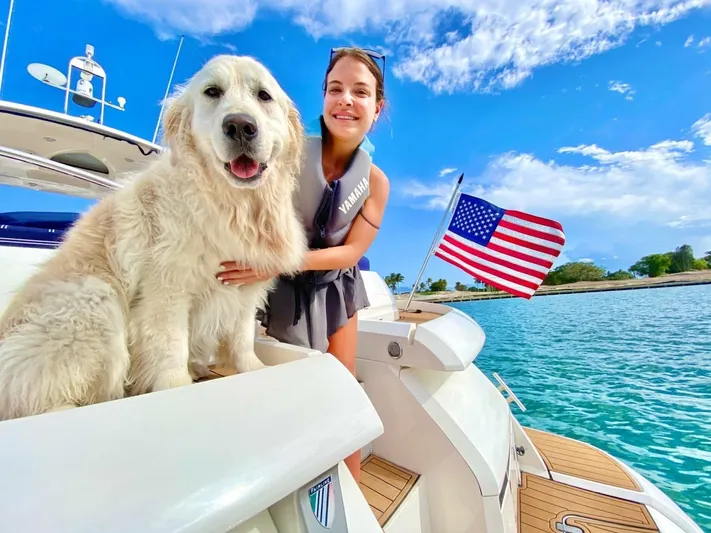 Mahalo Yacht Photos Pics Woman and dog on 2007 Fairline Targa 52 yacht with American flag, sunny day.
