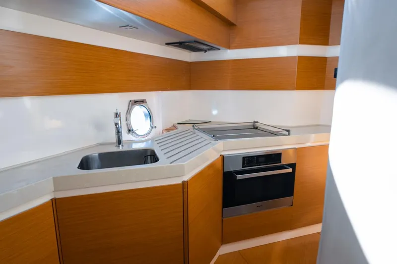 Seanner Yacht Photos Pics Modern kitchen interior on 2014 Azimut 45 Flybridge yacht, featuring sleek wood cabinetry and stainless steel appliances.