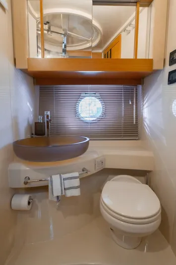 Seanner Yacht Photos Pics Luxurious bathroom in 2014 Azimut 45 Flybridge yacht with modern fixtures and porthole window.