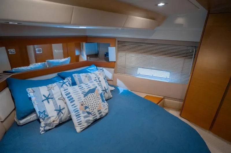 Seanner Yacht Photos Pics Luxurious bedroom interior of 2014 Azimut 45 Flybridge yacht with blue bedding and decorative pillows.
