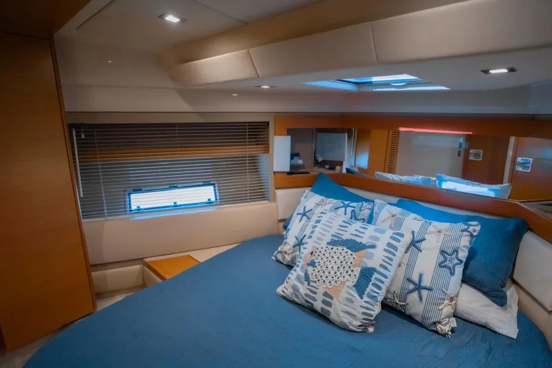 Seanner Yacht Photos Pics Luxurious bedroom interior of 2014 Azimut 45 Flybridge yacht with blue bedding and decorative pillows.