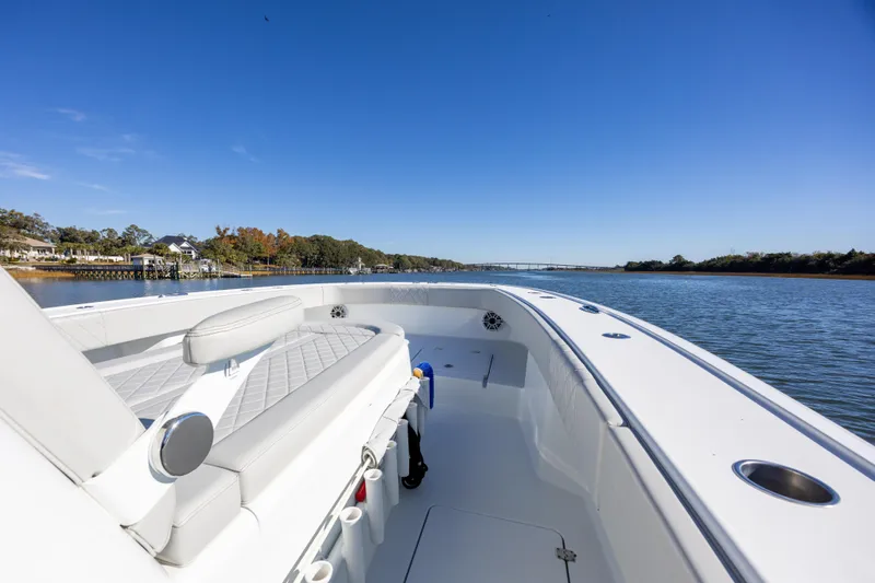  Yacht Photos Pics 2024 Freeman 38 boat cruising on a serene river under a clear blue sky.
