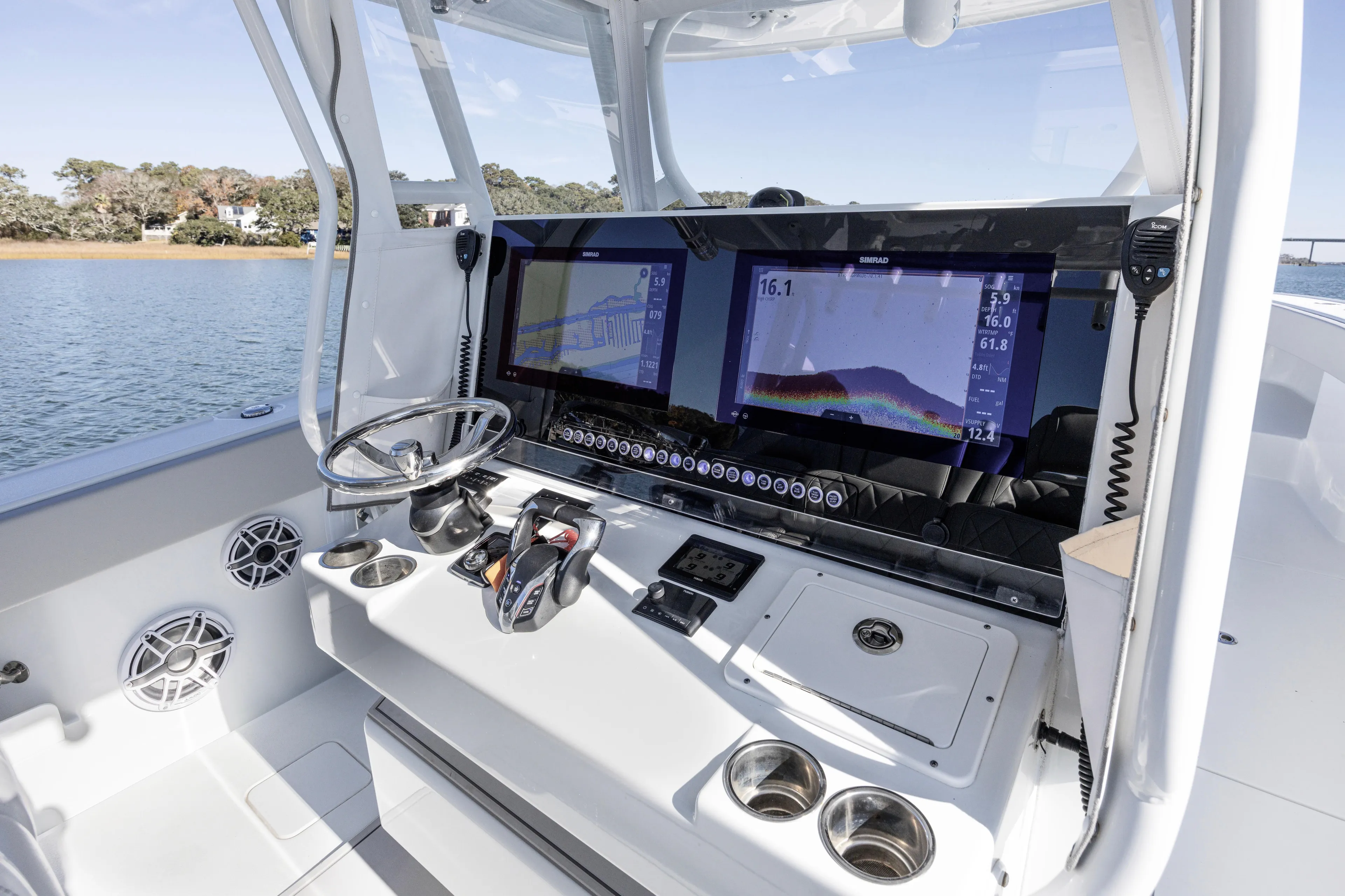  Yacht Photos Pics 2024 Freeman 38 boat dashboard with dual Simrad displays and steering wheel on water.
