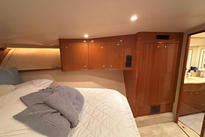 Journey Yacht Photos Pics Luxurious cabin interior of 2003 Viking 48 Convertible yacht with cozy bedding and wooden cabinetry.