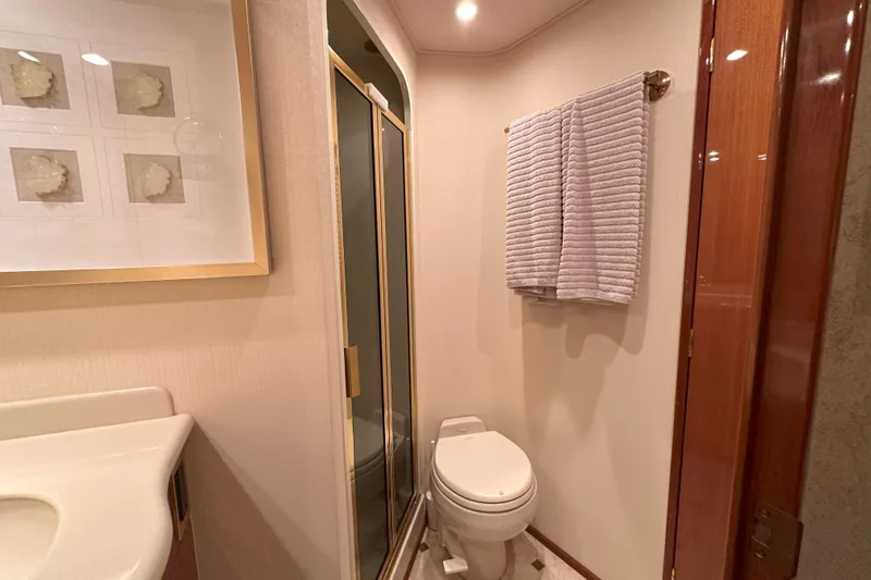 Journey Yacht Photos Pics Bathroom interior of 2003 Viking 48 Convertible yacht, featuring shower, toilet, and towel rack.