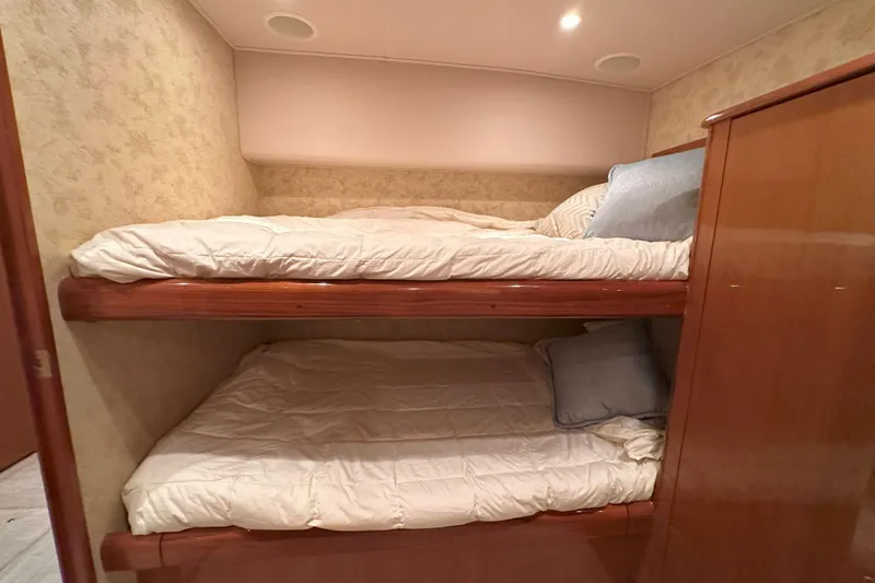 Journey Yacht Photos Pics Bunk beds in 2003 Viking 48 Convertible yacht cabin, featuring cozy bedding and wooden finishes.