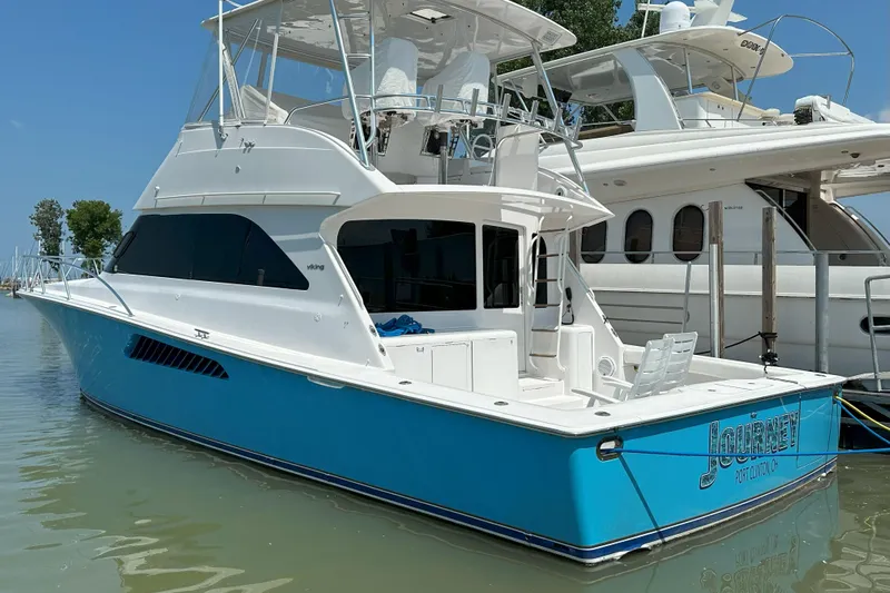 Journey Yacht Photos Pics 2003 Viking 48 Convertible yacht docked, featuring a sleek blue and white design.