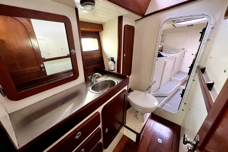  Yacht Photos Pics 2014 Custom Aluminum Expedition yacht bathroom with sink, mirror, and toilet, featuring wood accents.