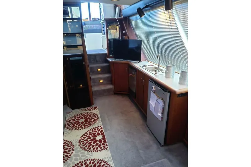  Yacht Photos Pics Interior of 1991 Bayliner 4588 Pilothouse with kitchenette, TV, and carpeted stairs.