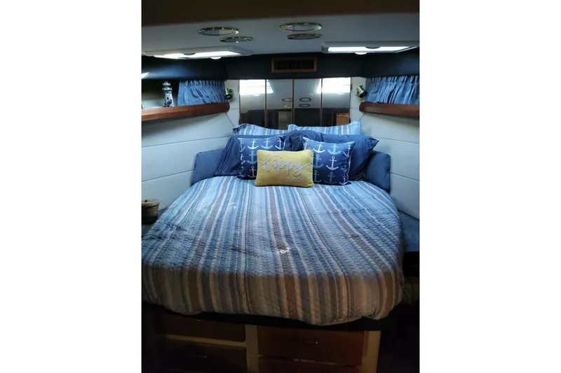  Yacht Photos Pics Cozy bedroom in 1991 Bayliner 4588 Pilothouse with nautical-themed bedding.