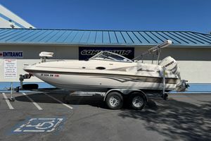 2007 Hurricane SunDeck 217 OB boat on trailer, parked outside a building.