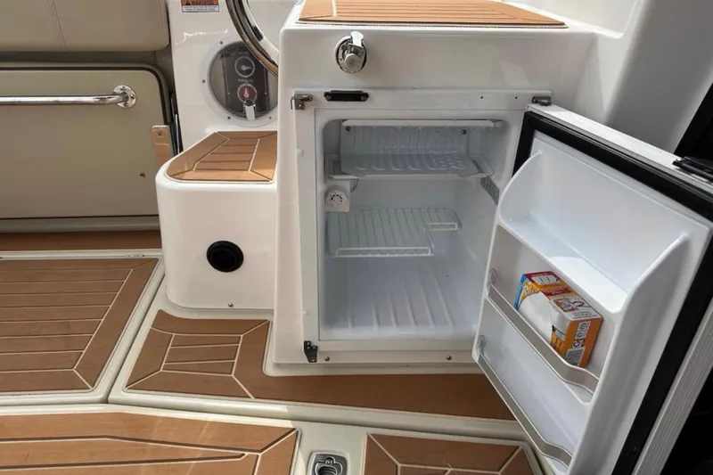 Flips Ahoy Yacht Photos Pics 2021 Ranger Tugs R-29 S boat interior with open mini fridge and wooden flooring.