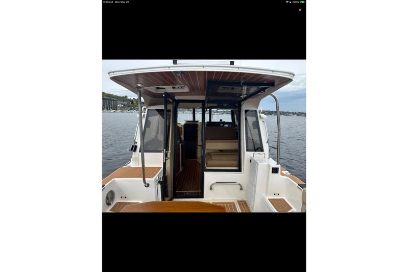 Flips Ahoy Yacht Photos Pics 2021 Ranger Tugs R-29 S boat, rear view, open cabin, docked on calm water.
